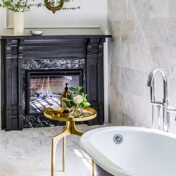 Black accent marble fireplace mantel in bathroom