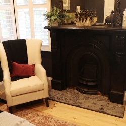 Black stone arched fireplace mantel in bedroom