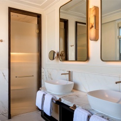 Fluted glass door and metal framed mirror in hotel bathroom