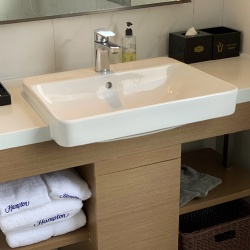 Hotel bathroom vanity with extruded ceramic basin