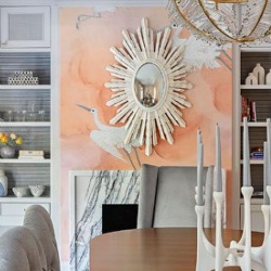 cream oval sunburst mirror over a marble fireplace